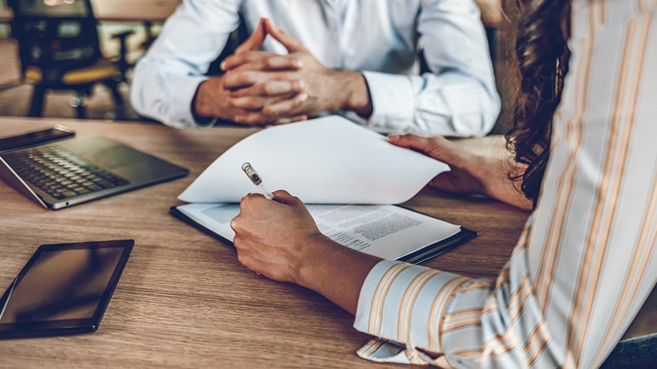 Personnes en train de travailler autour d'une table : zoom sur les mains 